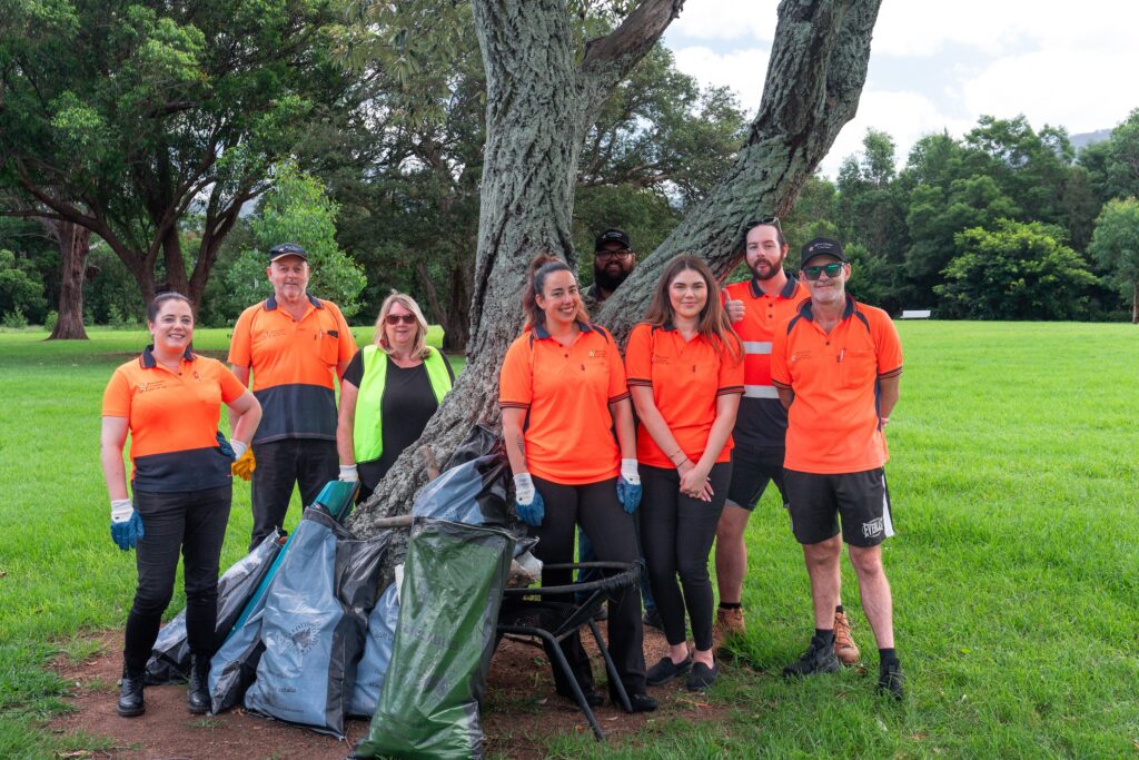 Team posing for a group photo after a community clean-up activity in the Southern Highlands