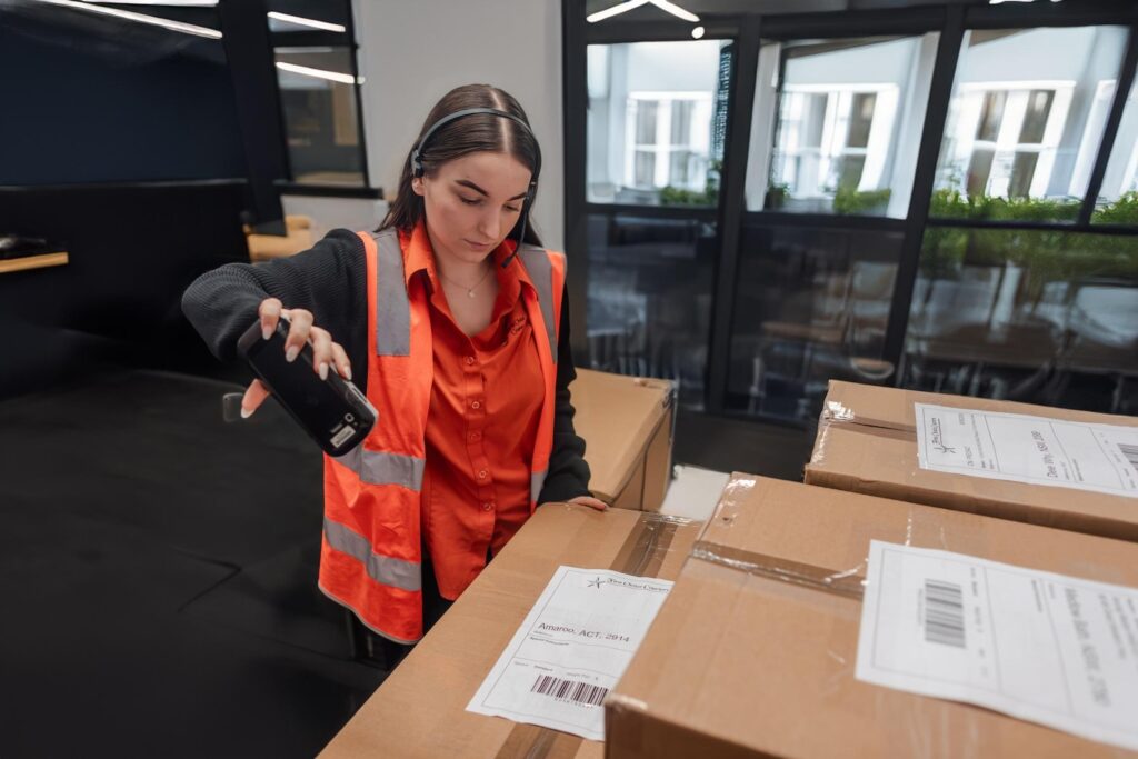 Female logistics worker scanning packages, Wollongong.